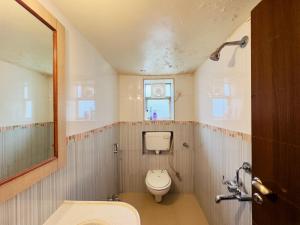a small bathroom with a toilet and a sink at Spellbound in Wadgaon +10 photos