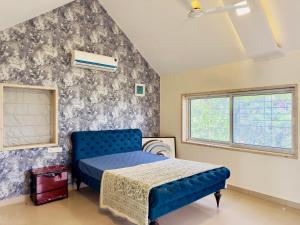 a bedroom with a blue bed and a wall at Spellbound in Wadgaon