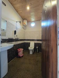 a bathroom with a toilet and a sink at Namaha hotel and cottages in Kanatal