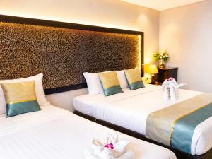a hotel room with two beds and an elephant headboard at The Regizt Jomtien Pattaya in Jomtien Beach