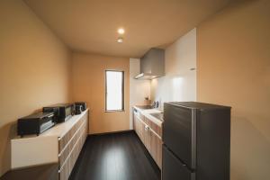 a kitchen with a black refrigerator and a sink at みたまの湯宿 in Beppu