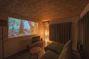 a living room with a couch and a flat screen tv at みたまの湯宿 in Beppu