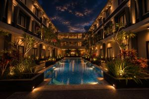 a swimming pool in the middle of a building with plants at ILLIRA Lite Praya Lombok in Praya