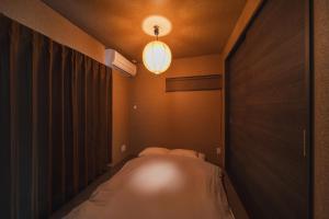 a small room with a bed and a light at みたまの湯宿 in Beppu