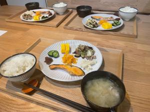 a table with plates of food and bowls of rice at 泊まれるカフェやわらかそう in Koka