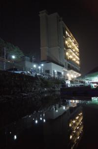a large building at night with a reflection in the water at Gapyeong Dolgorae Resort in Gapyeong