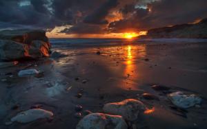 a sunset on a beach with the tide coming in at LIL Aroma in Galle