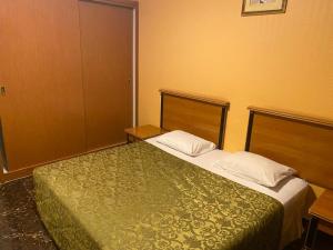 a bedroom with a bed with a green comforter at Hotel Al Masa in Al Buraymī +22 photos