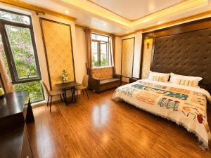 a bedroom with a bed and a desk and windows at Giang Ninh Hotel - Korean Town Bac Ninh in Bồ Sơn