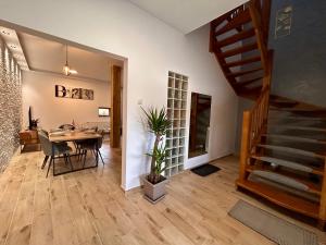 a dining room with a table and a staircase at BT Apartman in Miercurea-Ciuc