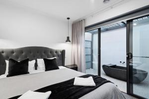 a bedroom with a large bed and a bath tub at Marine Cove in Yarrawonga +28 photos