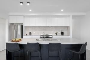 a kitchen with a counter with chairs and a sink at Marine Cove in Yarrawonga
