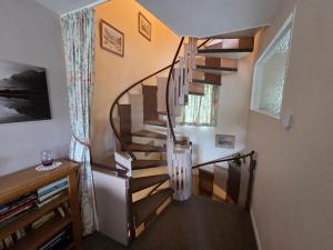 a spiral staircase in a room with a window at Mellbreak in Chapel Stile +14 photos