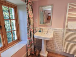 a bathroom with a sink and a mirror at Rose Cottage Coniston in Coniston +23 photos