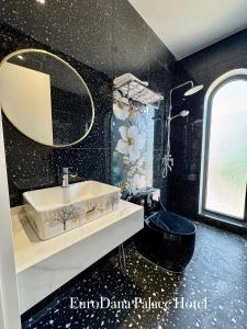 a bathroom with a sink and a toilet and a mirror at EuroDana Palace Hotel in Danang