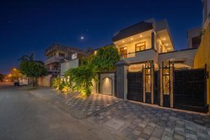 a house with a gate on a street at night at The Amber House - Luxury Boutique Stay in Bani Park, City Center Jaipur in Jaipur
