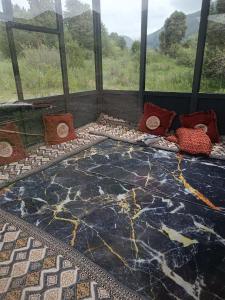 a room with a large stone floor with pillows on it at Archa in Osh