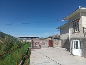 a house with a driveway next to a fence at Archa in Osh