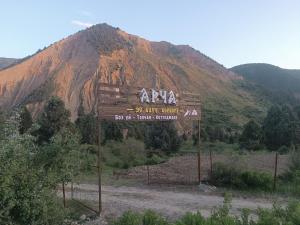 a sign in front of a mountain in the desert at Archa in Osh