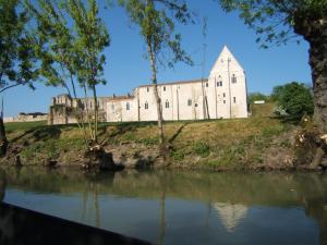 an old castle on a hill next to a river at Le Logis de bouillé in Bouillé-Courdault
