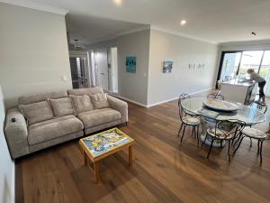 a living room with a couch and a table at Beach House Perth in Perth