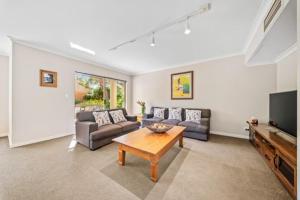 a living room with a couch and a television at Fairway Retreat in The Vines