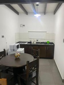 a kitchen with a table and a stove and a counter top at Cepas del Valle - cabañas y suites in Chilecito