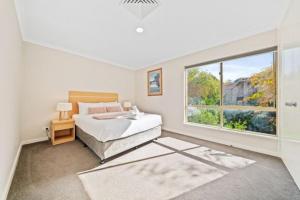 a bedroom with a bed and a large window at Fairway Retreat in The Vines
