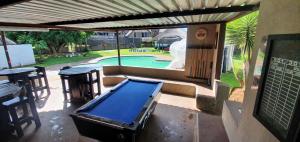 a pool table on a patio next to a swimming pool at Blu light lodge in Randfontein
