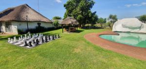 a game of chess in a yard next to a pool at Blu light lodge in Randfontein
