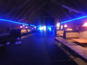 a dark room with tables and blue lights at Blu light lodge in Randfontein