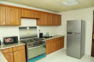 a kitchen with wooden cabinets and a stainless steel refrigerator at Samaraham Residency in Indāf