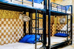 a room with two bunk beds with blue pillows at Hotel Amrapali Bhiwandi in Bhiwandi