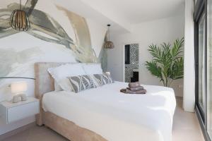 a bedroom with a white bed and a plant at Villa Don Grosa - Luxury Family Retreat in Torre-Pacheco +67 photos
