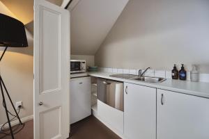 a kitchen with white cabinets and a sink at Briarwood in Greytown