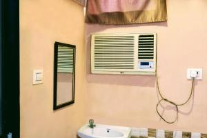 a bathroom with a sink and a air conditioner at Hotel Amrapali Bhiwandi in Bhiwandi