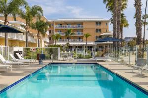a swimming pool in front of a hotel with palm trees at Jamaica Bay Inn Marina Del Rey Tapestry Collection by Hilton in Los Angeles +56 photos