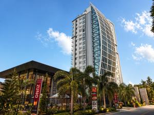 a tall building with palm trees in front of a street at The Elysium Prațumnak Pattaya - By SHG in Pattaya South +33 photos
