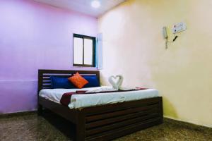 a bedroom with a bed with blue and red pillows at Hotel Amrapali Bhiwandi in Bhiwandi +18 photos