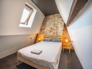 a bedroom with a bed in a room with a brick wall at Two-bedroom apartment by the river in Antwerp