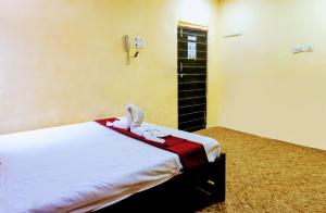 a bedroom with a bed with towels on it at Hotel Amrapali Bhiwandi in Bhiwandi