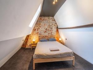 a attic bedroom with a bed in a brick wall at Two-bedroom apartment by the river in Antwerp +53 photos