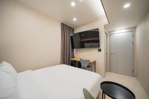 a hotel room with a bed and a desk at Calm Rest Hotel Masan in Changwon