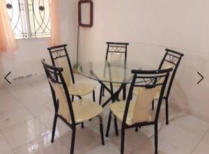 a glass dining room table with four chairs around it at Villa Venesia Berastagi Resort in Berastagi