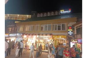 a group of people walking in a street at night at The Moonsoon Inn in Mussoorie