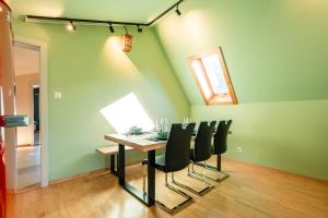 a dining room with a table and black chairs at Steinbockblick Maienfeld in Maienfeld