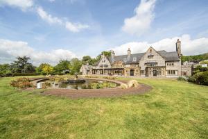 a large house with a pond in the yard at Harcombe House&nbspPet Free Bungalow in Newton Abbot