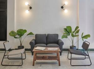 a living room with a couch and two chairs and a table at Poshtel VNS in Varanasi