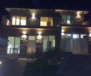 una casa iluminada por la noche con luces en La Casa de Liber en Tandil
