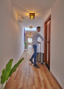 a man standing in a hallway with a suitcase at Poshtel VNS in Varanasi